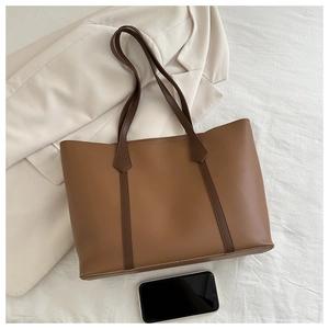 Flache Ansicht einer großen karamellbraunen Leder-Tote-Bag mit braunen Riemen auf Blazer