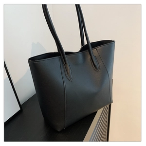 Detailed view of stitching on the side of a large black matte leather tote shoulder bag