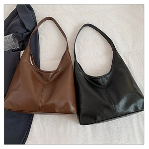 Detail of dark brown and black large capacity tote bags with faux leather texture