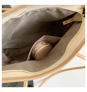 Interior detail of large capacity tote bag showing grey lining and zipper pocket