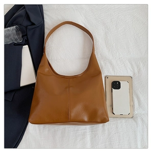Detail view of large vintage brown tote bag with leather texture and daily essentials