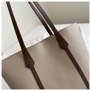 Detailansicht der beigen Shopper-Tasche mit braunen Trägern, feinen Nähten und PU-Leder