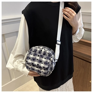 Close-up of blue and white plaid saddle bag with black heart prints and adjustable strap