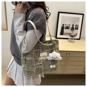 Detail of woven canvas tote bag with geometric patterns and plush cloud keychain