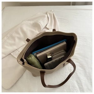 Detailansicht der geräumigen beige Shopper-Tasche mit Tablet, Schirm und Alltagsgegenständen