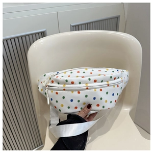 Detailed view of white canvas fanny pack with colorful polka dots and dual zippers