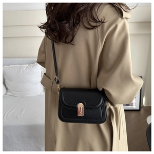 Side view of a black matte leather crossbody bag with a gold twist lock on a model