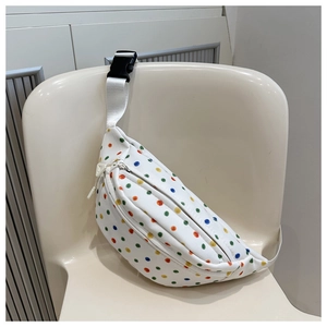 Detail view of white crossbody bag with vibrant colorful polka dots and plastic buckle