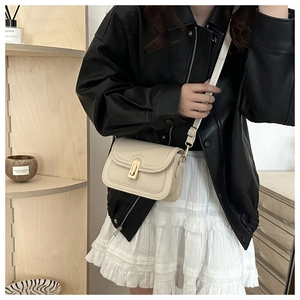 Chic cream small square bag with gold twist lock styled on a model with black leather jacket