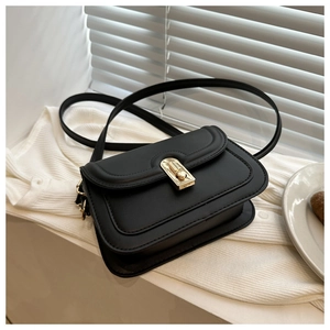 Detail of matte black leather bag with gold rectangular twist lock and premium stitching