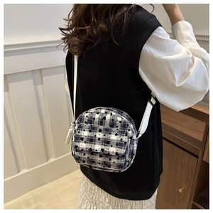 Detail of checkered round crossbody bag with heart pattern and adjustable strap