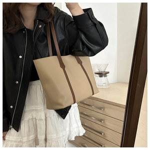 Detail der beigen Shopper-Tasche mit braunen Riemen, kombiniert mit schickem Mode-Outfit