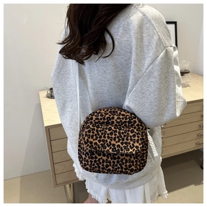 Detail of leopard print mini crossbody bag with flap closure and white shoulder strap