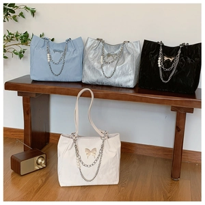 Group shot of four large tote bags in silver, black, blue, and beige with pearl charms