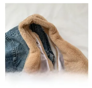 Detailopname van een kameelkleurige pluche draagtas met zachte textuur tegen denim
