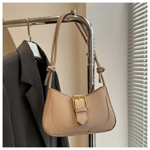 Détail du sac croissant beige avec boucle dorée et bandoulière en cuir nouée