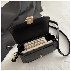 Interior view of black leather crossbody bag showing space for phone and wallet