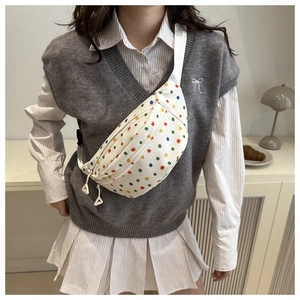 Detail of white saddle bag with colorful polka dots and adjustable wide strap
