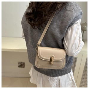 Chic beige crossbody bag featuring a sleek gold bar lock and smooth faux leather texture
