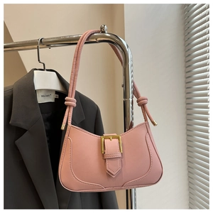 Détail du sac sous l'aisselle en similicuir rose avec boucle dorée et nœuds stylés