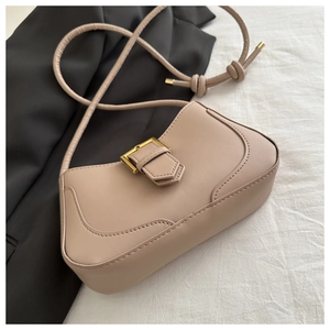 Détail du sac à bandoulière nude avec boucle dorée et bandoulière à design noué unique