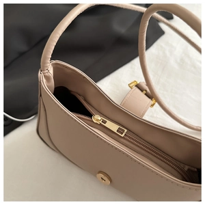 Détail du sac sous le bras avec fermeture éclair, bouton aimanté et poche intérieure