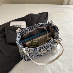 Large blue white striped tote bag with leather straps showing spacious interior for essentials