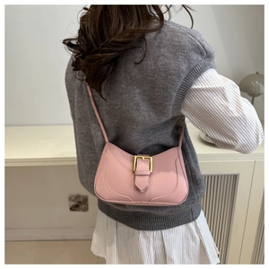 Vue détaillée du sac croissant rose avec boucle dorée et fine bandoulière sur un modèle