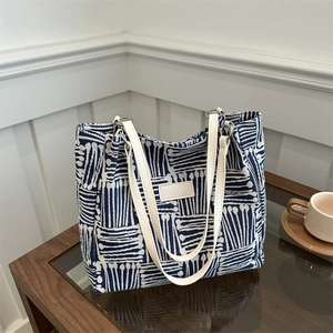 Large blue and white geometric canvas tote bag with cream leather handles for daily commute