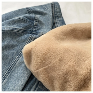 Gros plan sur la texture douce en fausse fourrure marron du sac sur tissu denim bleu