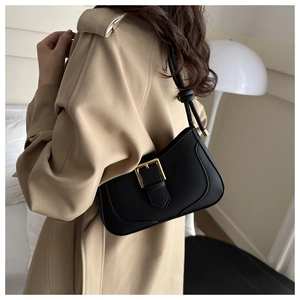 Détail du sac sous l'aisselle noir minimaliste avec boucle dorée et finition en cuir mat
