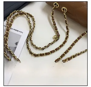 Close-up of brown quilted leather woven with gold metal chain strap on a stylish bag