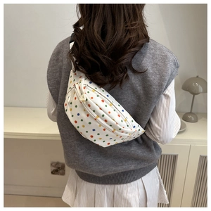 Rear view of a white crescent crossbody bag with colorful rainbow polka dot patterns