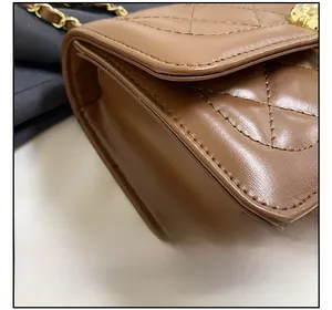Detail view of brown quilted leather bag with gold chain strap and precise stitching