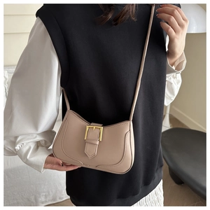 Détail du sac croissant beige avec boucle dorée et texture en cuir PU sur le modèle