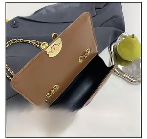 Interior view of brown quilted crossbody bag showing smooth lining and gold twist lock