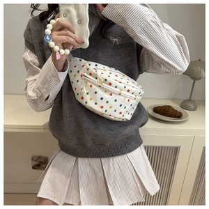 Close-up of white canvas waist bag with colorful dots and geometric zipper pulls