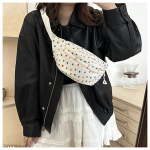 Detailed shot of a white saddle bag with colorful polka dots on an adjustable strap