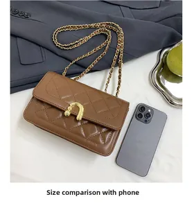 Detailed size comparison of brown quilted crossbody bag with a smartphone and chain strap