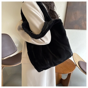 Gros plan du sac cabas en fausse fourrure noire avec texture douce sur l'épaule