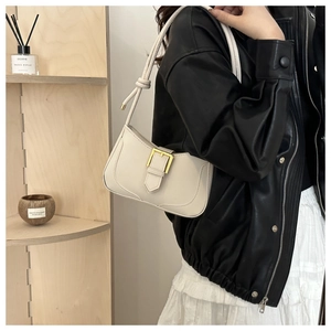 Détail du sac à bandoulière crème avec boucle dorée et bandoulière en corde