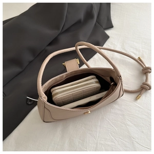 Vue intérieure du sac à bandoulière beige montrant sa capacité pour un portefeuille