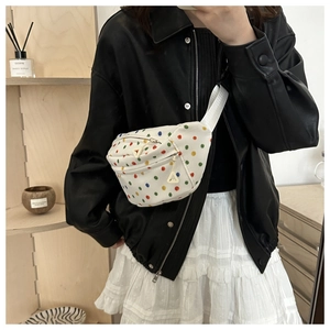 Detail of white canvas crossbody bag with colorful polka dots and double zippers