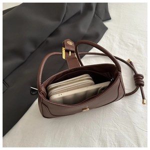 Vue de dessus montrant le rangement intérieur du sac à bandoulière en cuir marron avec sac