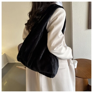 Détail d'un grand sac cabas en peluche noire montrant la texture douce de la fausse fourrure