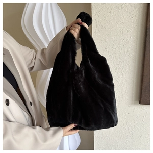 Gros plan d'un sac cabas noir en peluche montrant la texture douce et la poignée en U