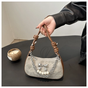 Detail of grey niche shoulder bag with leather knots and silver bow and pearl charms