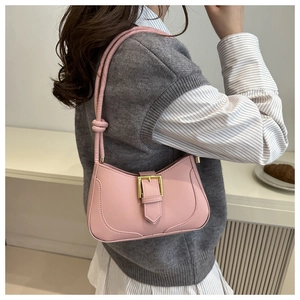 Détail du sac demi-lune rose avec boucle dorée et bandoulière à nœud style contemporain