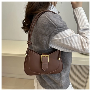 Détail latéral du sac croissant marron avec boucle dorée et bandoulière à nœud chic