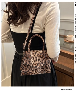 Detail view of leopard print shoulder bag with metal buckle and adjustable leather strap